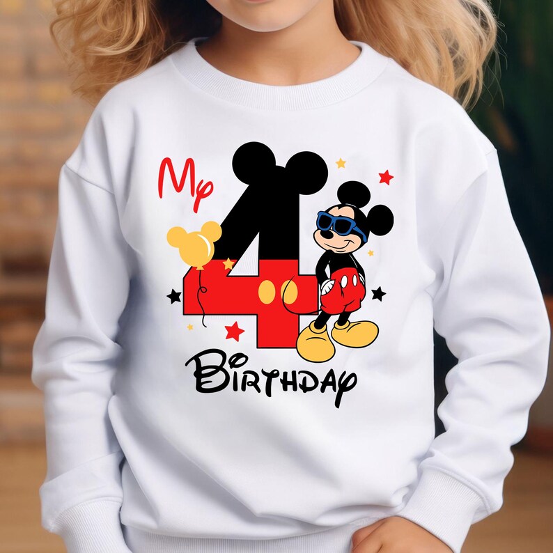 May include: White sweatshirt featuring a colorful graphic of Mickey Mouse with sunglasses, the number 4 in red, and the words "My Birthday". The design includes stars and a yellow balloon. A fun birthday-themed top.