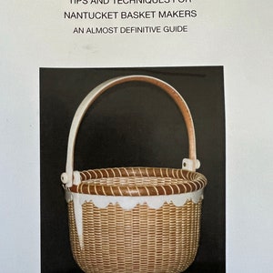 May include: A Nantucket basket with a white handle and rim, and a woven body. The basket has a scalloped white trim and is set against a black background. Text at the top reads "TIPS AND TECHNIQUES FOR NANTUCKET BASKET MAKERS AN ALMOST DEFINITIVE GUIDE."