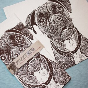 May include: Two brown and white tea towels with a black and white illustration of a boxer dog. The towels are hand printed and have the text "FuzzyMug Hand Printed Flour Sack Tea Towel" on the bottom.