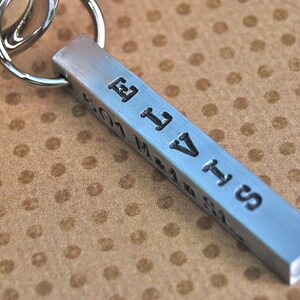 May include: A silver metal keychain with a rectangular bar engraved with the name "Elvis" and the date "2011".