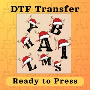 May include: DTF Transfer design featuring letters A, B, H, A, I, L, M, and S, each adorned with a Santa hat and reindeer antlers. The letters are black and decorated with Christmas lights. The text "Ready to Press" is at the bottom.