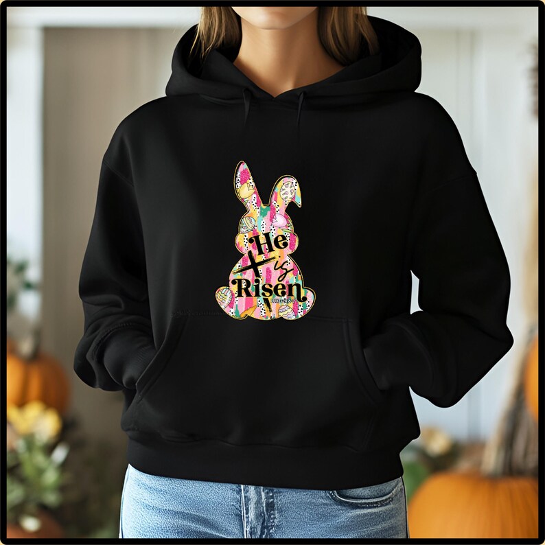 a person wearing a black hoodie with a colorful bunny on it