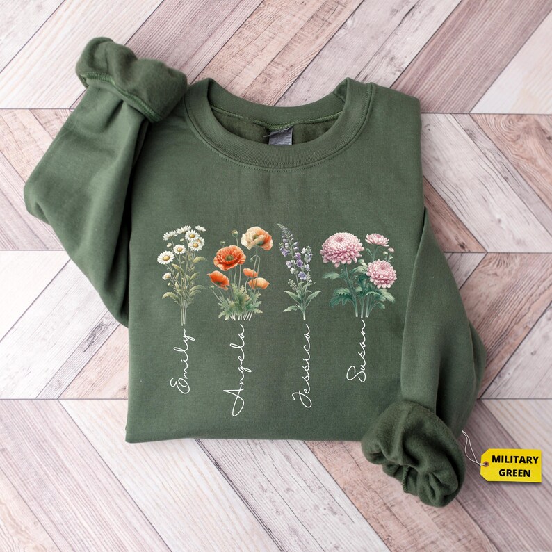 a green sweatshirt with flowers on it on a wooden floor