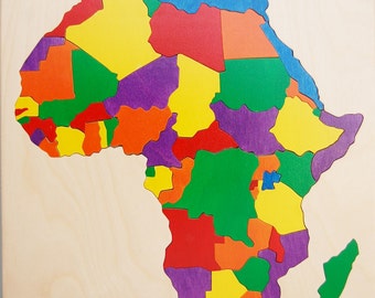 Könnte beinhalten: Ein Holzpuzzle des afrikanischen Kontinents mit einzelnen Länderteilen in verschiedenen Farben. Das Puzzle befindet sich auf einer hellen Holzbasis, wobei jedes Land in leuchtenden Farben wie Rot, Gelb, Grün und Lila bemalt ist.