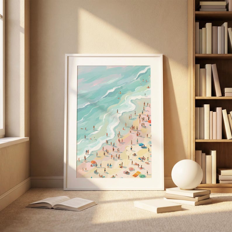 May include: A framed art print depicts a vibrant beach scene. Turquoise waves crash onto a sandy shore dotted with numerous figures, colorful umbrellas, and beach towels. The artwork is encased in a white frame, creating a serene coastal aesthetic.
