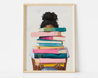 May include: A framed art print depicting a person holding a stack of books. The books have spines in shades of pink, teal, yellow, and green. The person's hair is styled in a bun, and they are wearing a light blue top.