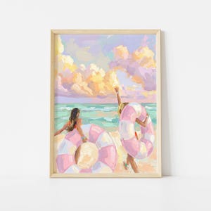 May include: A framed painting depicts a beach scene with two figures and two pink and white striped inflatable rings. The sky is filled with pastel clouds, and the ocean is a turquoise color. The artwork is in a soft, impressionistic style.