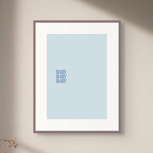 May include: A framed print with a light blue background and the word "BABY" repeated four times in a dark blue font.