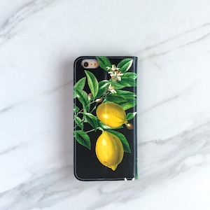May include: Black phone case with a lemon tree design. The case features two yellow lemons and green leaves on a black background.