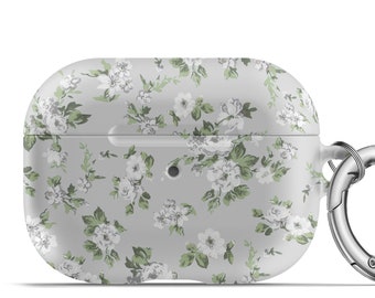 May include: A gray AirPod case with a floral pattern of white roses and green leaves. The case has a silver carabiner clip attached for easy carrying. The design is a light, feminine aesthetic.