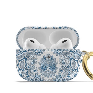 Peut inclure: &Eacute;tui blanc pour Airpods avec un motif floral bleu et blanc et un anneau en m&eacute;tal dor&eacute;.