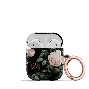 May include: A black and white floral print Airpods case with a rose gold carabiner clip. The case has a pink rose design and the letter "m" in rose gold.