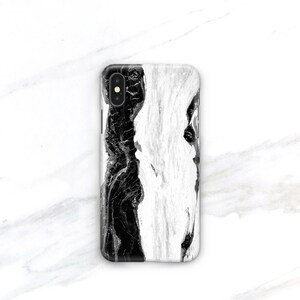 May include: Black and white marble phone case with a black camera lens.