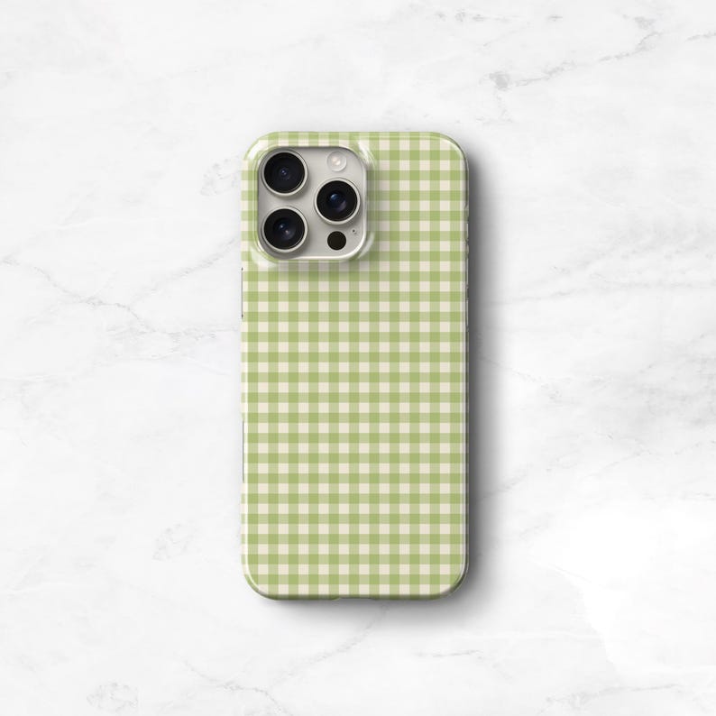 Pu&ograve; includere: Una custodia per telefono con un motivo a quadretti verde e bianco. La custodia ha una finitura lucida e un ritaglio per la fotocamera. La custodia &egrave; progettata per uno smartphone.