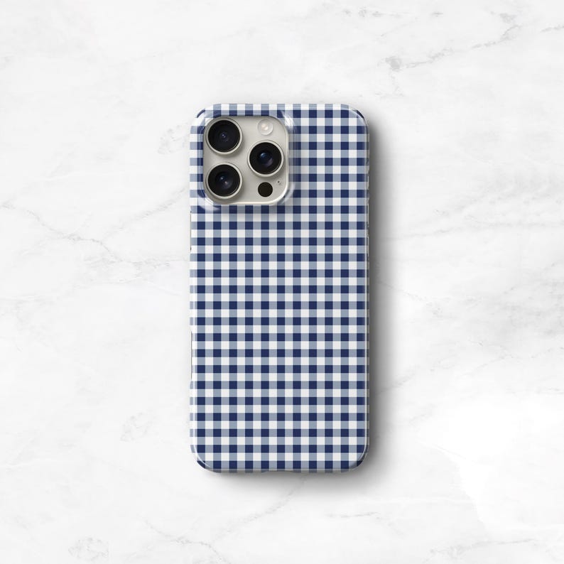 Pu&ograve; includere: Una custodia per telefono con motivo a quadretti blu navy e bianco. La custodia ha un design a guscio rigido e presenta un ritaglio per la fotocamera. La custodia &egrave; progettata per adattarsi a uno smartphone.