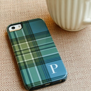 May include: A blue and green plaid phone case with a white letter "P" on the back.