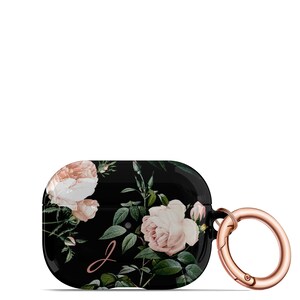 May include: Black Airpods case with a floral design featuring pink roses and green leaves. The case has a rose gold carabiner clip.