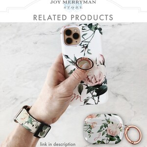 Op de afbeelding: Een witte telefoonhoes met een bloemenontwerp met roze rozen en groene bladeren. De hoes heeft een ringhouder van roosgoud aan de achterkant. Een bijpassend horlogebandje met bloemenontwerp en een witte Airpod-hoes met een bloemenontwerp en een roosgoud ring zijn ook te zien.