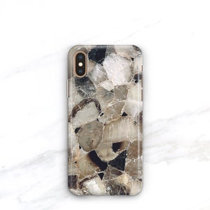 May include: A clear phone case with a brown and white geometric pattern. The case has a raised camera bump and a gold trim.