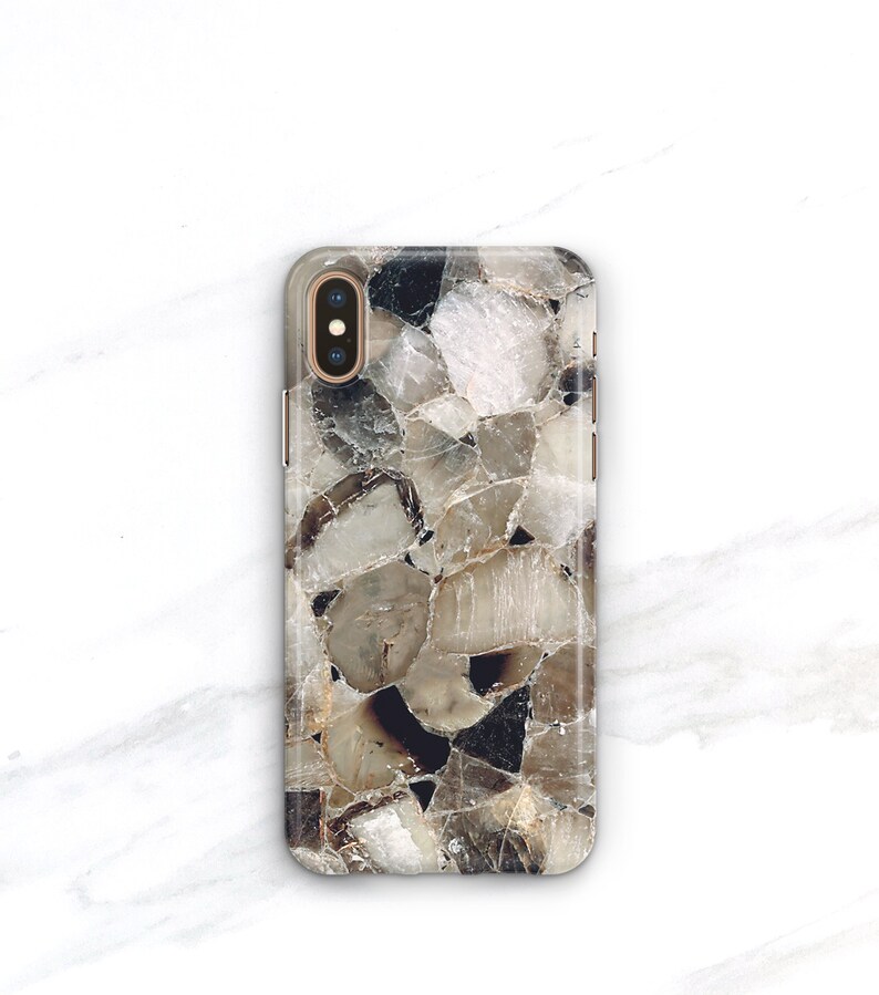 May include: A clear phone case with a brown and white geometric pattern. The case has a raised camera bump and a gold trim.