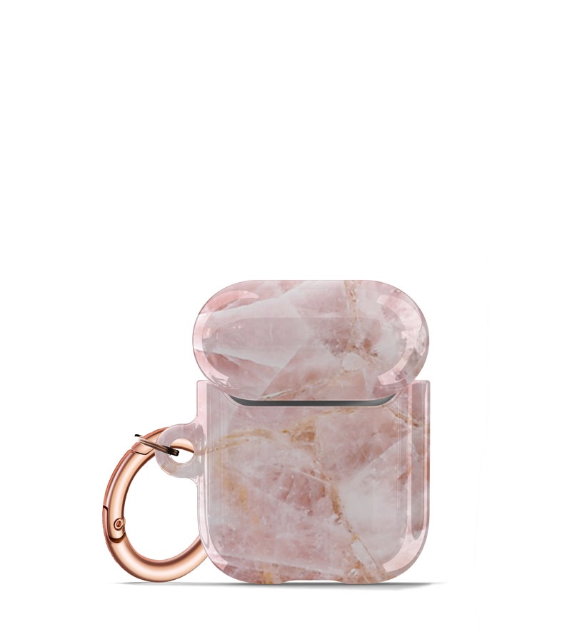 May include: A pink and white marble patterned Airpods case with a rose gold carabiner clip.