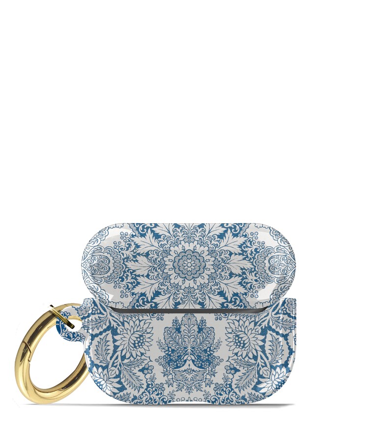 Peut inclure: Un &eacute;tui pour Airpods &agrave; motif blanc et bleu avec un mousqueton dor&eacute;. L'&eacute;tui pr&eacute;sente un motif floral avec des accents bleus.