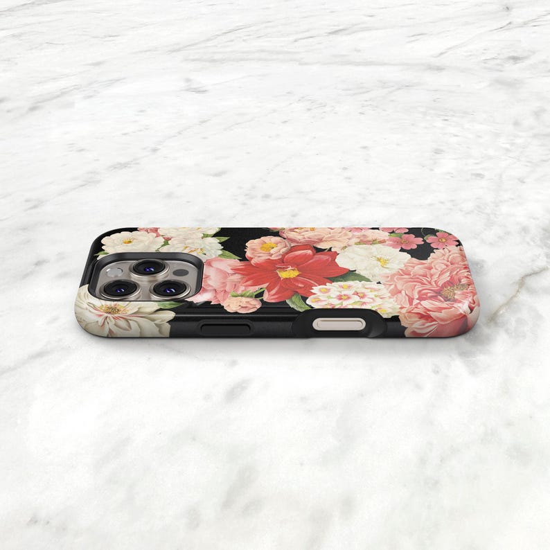 a smartphone case with a floral design, resting on a white surface.