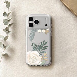 A clear phone case with a floral design featuring a white rose and green leaves is placed on a beige surface.