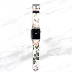 Op de afbeelding: Een witte Apple Watch met een band met bloemenprint. De band heeft roze en groene rozen en bladeren.