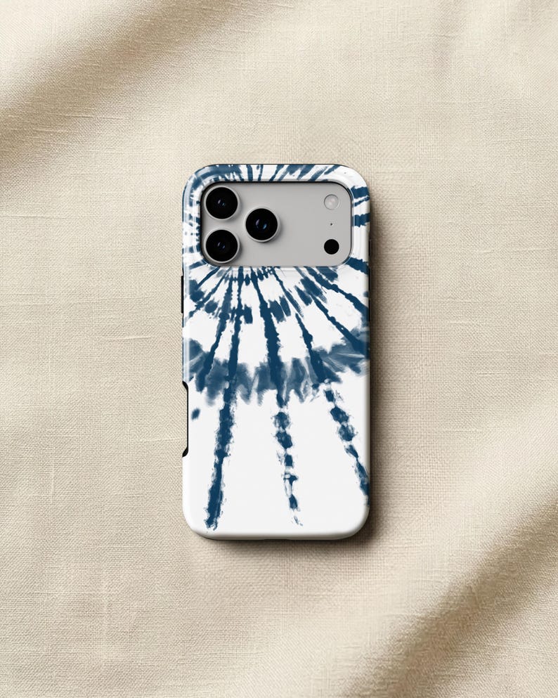 a white phone case with a tie-dye design on it, placed on a beige fabric background.