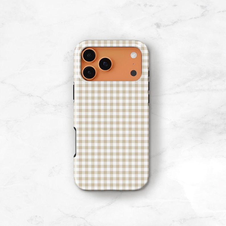 May include: A phone case with a tan and white gingham pattern. The case has a camera cutout with three lenses and a flash. The case is made of a hard plastic material and has a smooth finish.