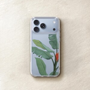 a clear phone case with a design of green leaves and a red flower on it.