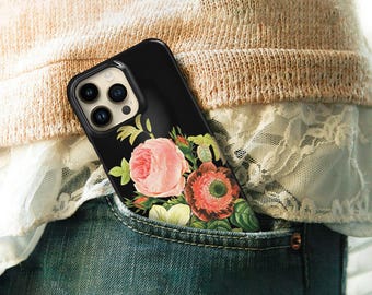 May include: A black smartphone case featuring a detailed botanical illustration of a large pink rose and a dark red flower with green leaves. The case has a cutout for a triple-lens camera system and is partially tucked into a blue denim pocket.
