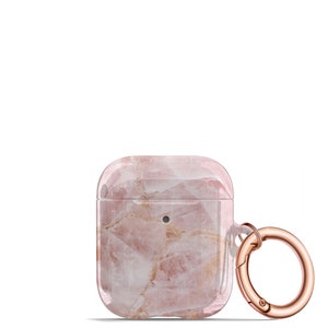 May include: A clear pink and white marble patterned phone case with a rose gold metal ring and clasp.