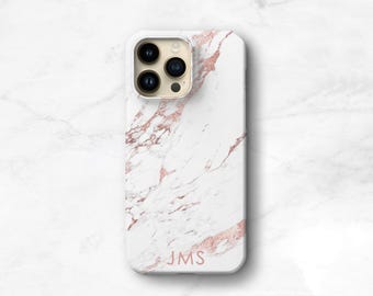 May include: A white phone case with a rose gold marble pattern and the letters JMS printed in rose gold at the bottom. The case features a cutout for a triple-lens camera system with a gold-toned border around the camera lenses.