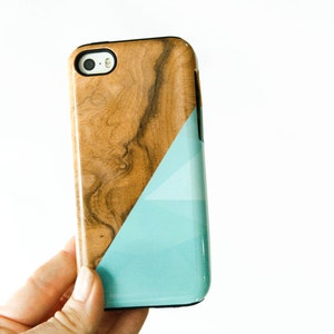 May include: A phone case made of wood and blue with a geometric design. The case is made from real wood and has a natural wood grain.