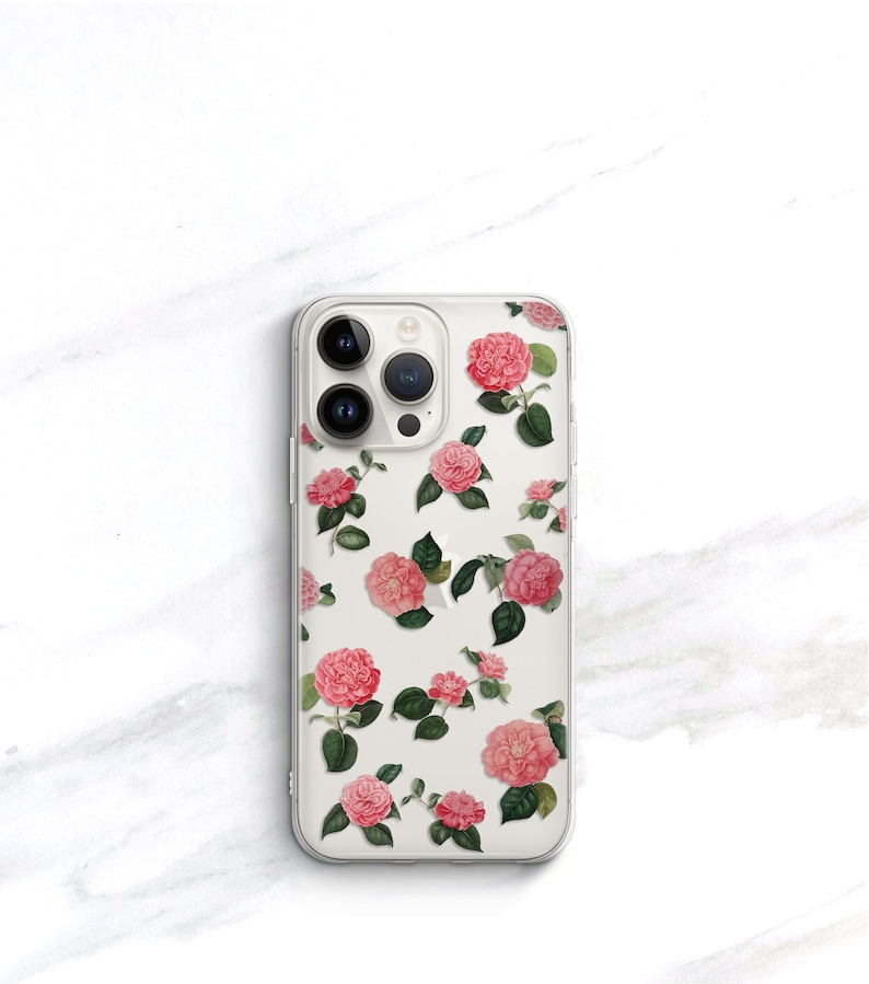 May include: A clear phone case with a floral design featuring pink and white camellias on a white background.
