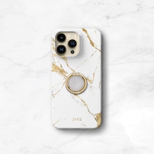 May include: White iPhone case with a gold marble design and a gold ring holder. The case has the initials "JMS" printed on the back.