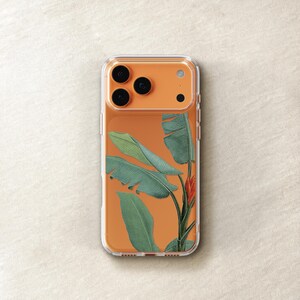 a clear phone case with a design of green leaves and a red flower on the back.