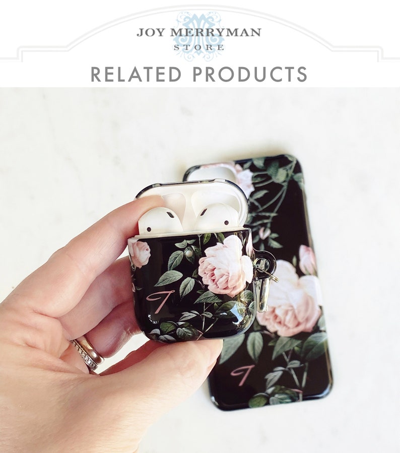 May include: A black phone case and a matching Airpods case with a floral design featuring pink roses and green leaves. The cases have a pink letter "J" on them.