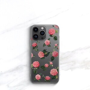 May include: A clear phone case with a floral design. The case features pink flowers with green leaves on a gray background.