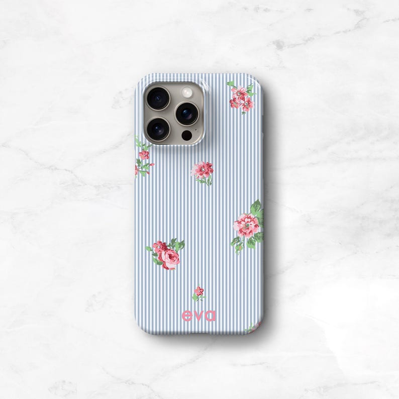 A blue and white seersucker striped phone case with delicate pink flowers personalized with the name 'eva' printed on the bottom. timeless East Coast prep