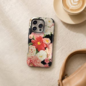 a floral phone case, a cup of coffee, and a purse on a table.