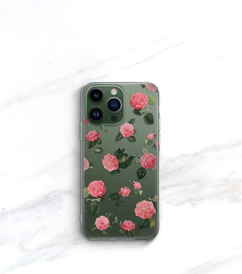 May include: A clear phone case with a floral design. The case features pink flowers with green leaves on a green background.