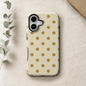 Puede incluir: Una funda rectangular para smartphone con fondo beige claro y un patrón repetitivo de lunares de color amarillo mostaza. La funda incluye una zona de recorte negra para la lente de la cámara en la esquina superior izquierda con dos lentes.