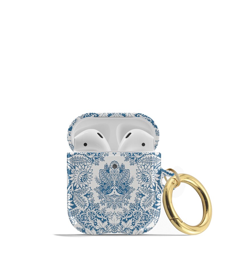 Peut inclure: Un &eacute;tui blanc pour Airpods avec un motif floral bleu et blanc et un porte-cl&eacute;s en m&eacute;tal dor&eacute;.