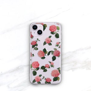 May include: Clear phone case with a pink floral pattern. The case has a cutout for the camera lens.