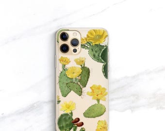 May include: A clear smartphone case featuring a botanical illustration of green prickly pear cactus pads and vibrant yellow flowers. The design is scattered across the transparent surface, showcasing the phone's camera lenses in the upper left corner.