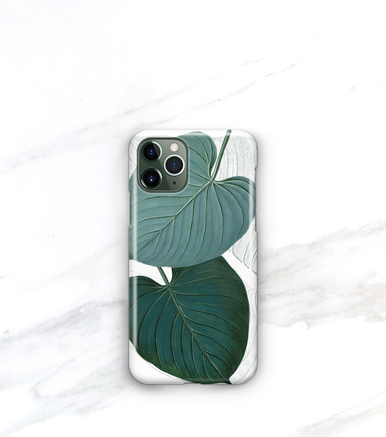 May include: A white phone case with a green leaf design. The leaves are detailed and realistic, with a light green color and dark green veins.