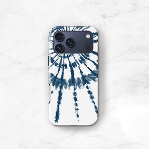 a white phone case with a tie-dye design on it, placed on a marble surface.